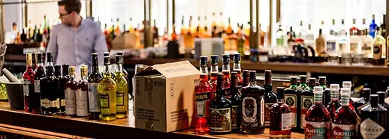 A bar with boxes of stock and bottles on the countertop